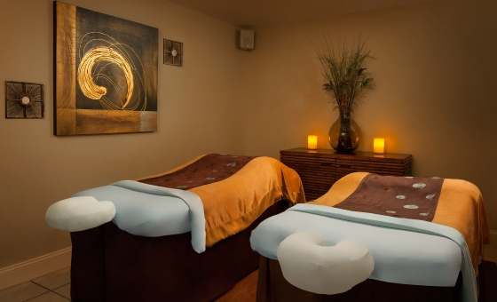 Massage beds in an ambient lit room with neutral colored walls.