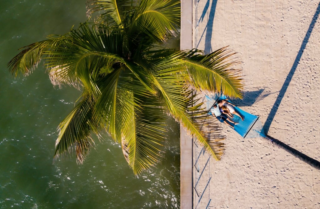 Aerial shot of couple laying in a blue hammock on the pier.