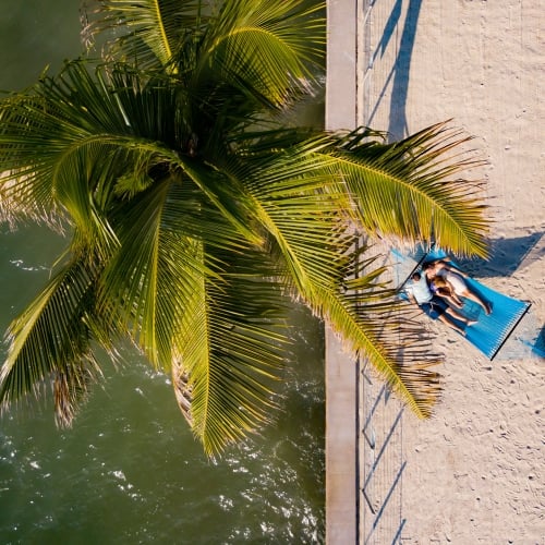 Aerial shot of couple laying in a blue hammock on the pier.