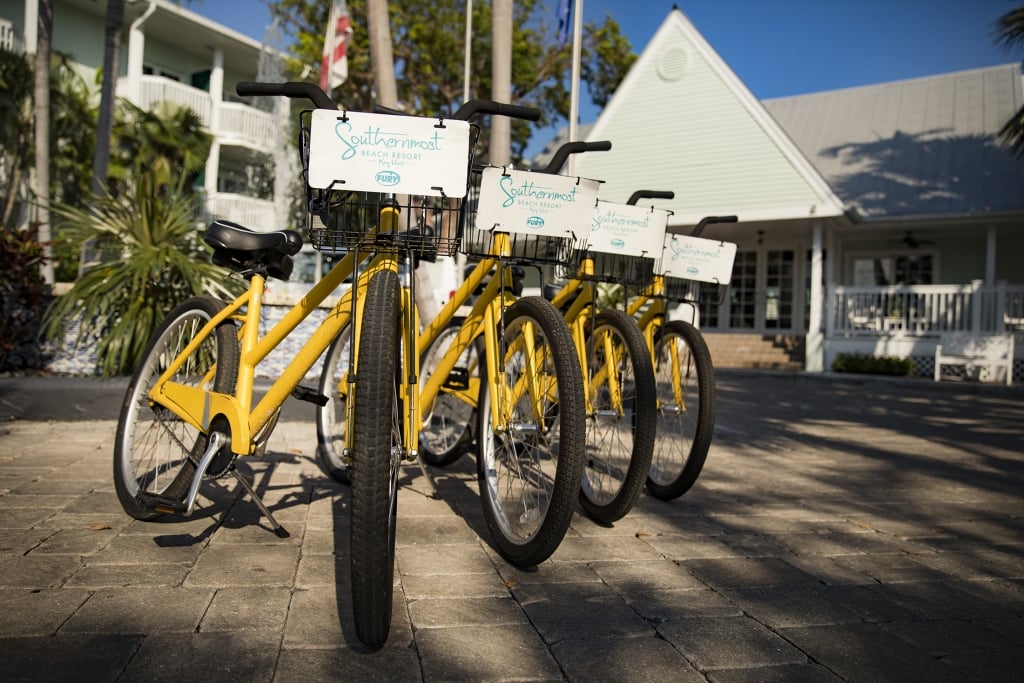 Four yellow rental bikes lined up side by side with Southernmost Logo