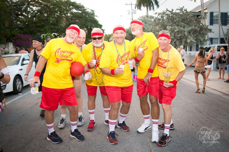 Group of six elderly men smiling at Fantasy Fest in their matching Average Joe's dodgeball costumes.