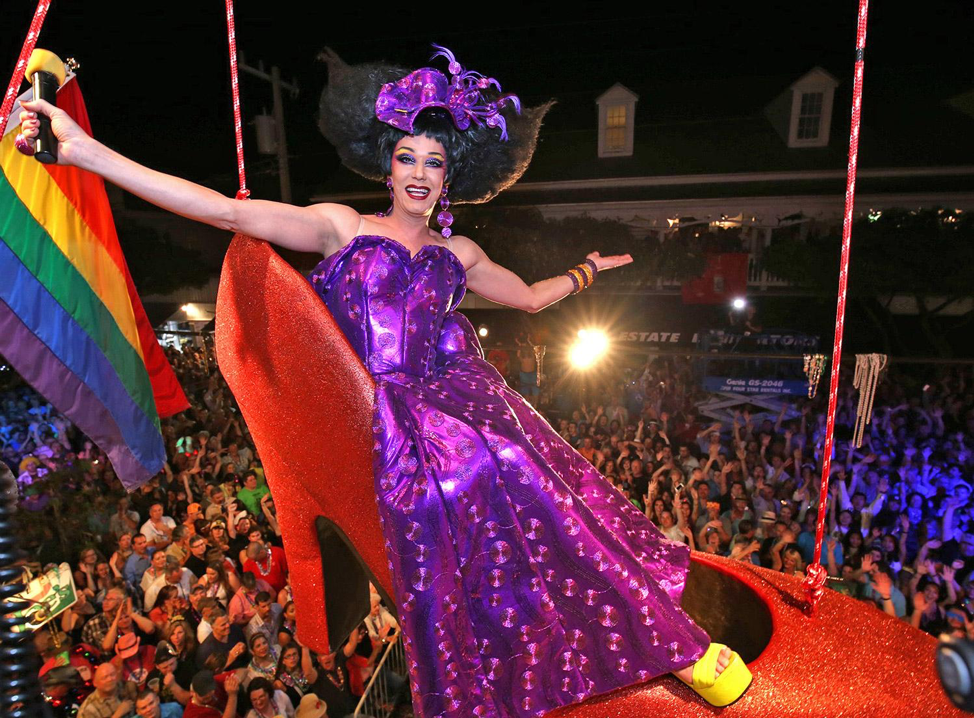 A drag queen sits in an over-sized red high-heeled shoe, suspended in the air, during a New Year's Eve performance on Duval Street.