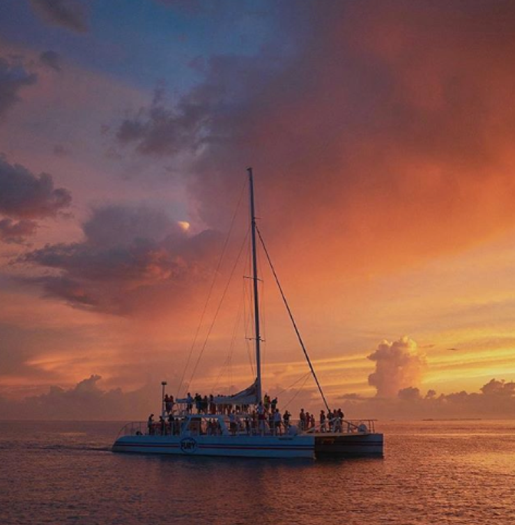 Sailboat full of tourists watching the sunset on the Historic Seaport.