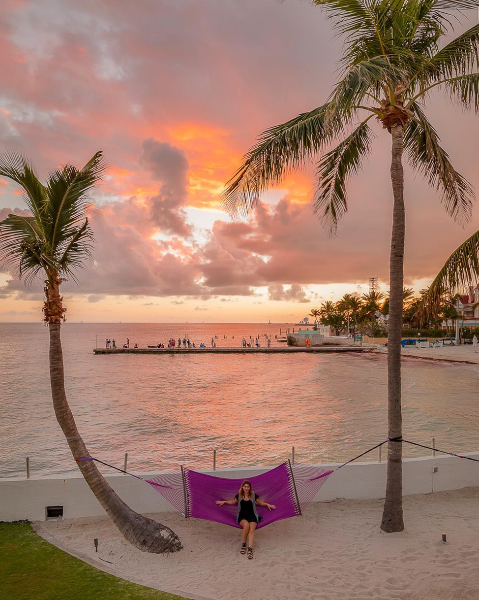 Young woman posing in a purple hammock at sunset at the Southernmost Beach Resort.