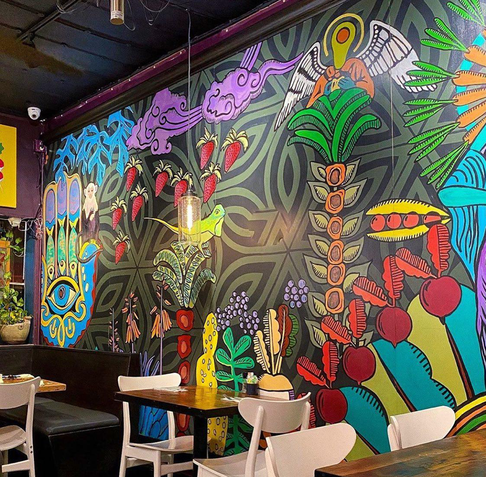 Cafe wall is painted with vibrant colors and artistic scenery