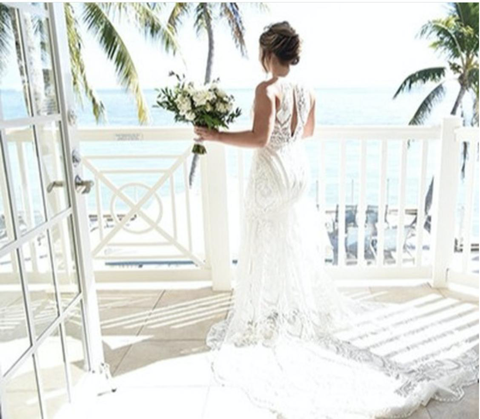 Woman in wedding dress holding a bouquet. 