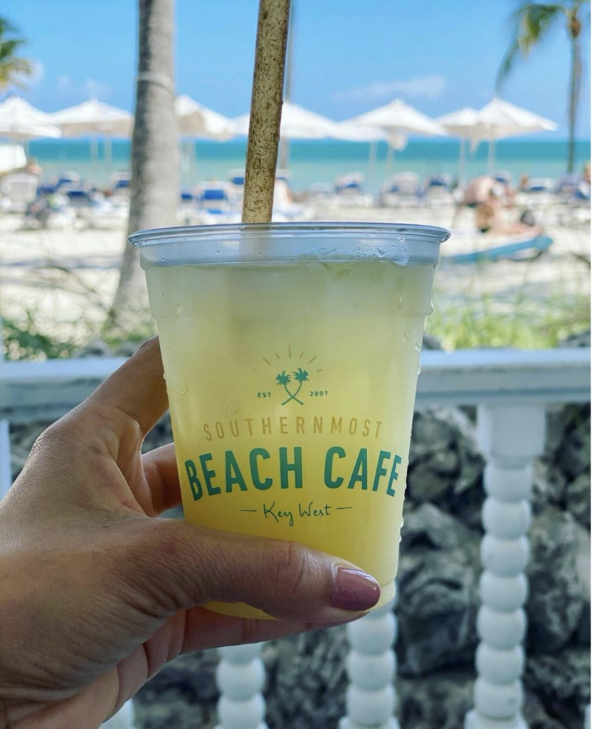 View from front porch with full cold drink and faded beach background.