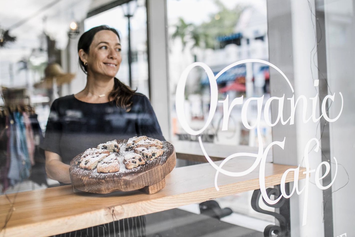 woman displaying baked goods at Green Pineapple Organic Cafe