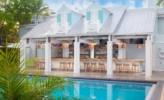 Pinapple Pool the beach club bar at The Westin Key West: a serene oasis surrounded by palm trees and lounge chairs.