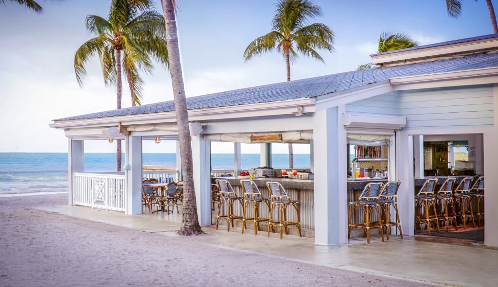 Southernmost beach restaurant by the ocean; outdoor beach restaurant facing the ocean and palm trees during the day