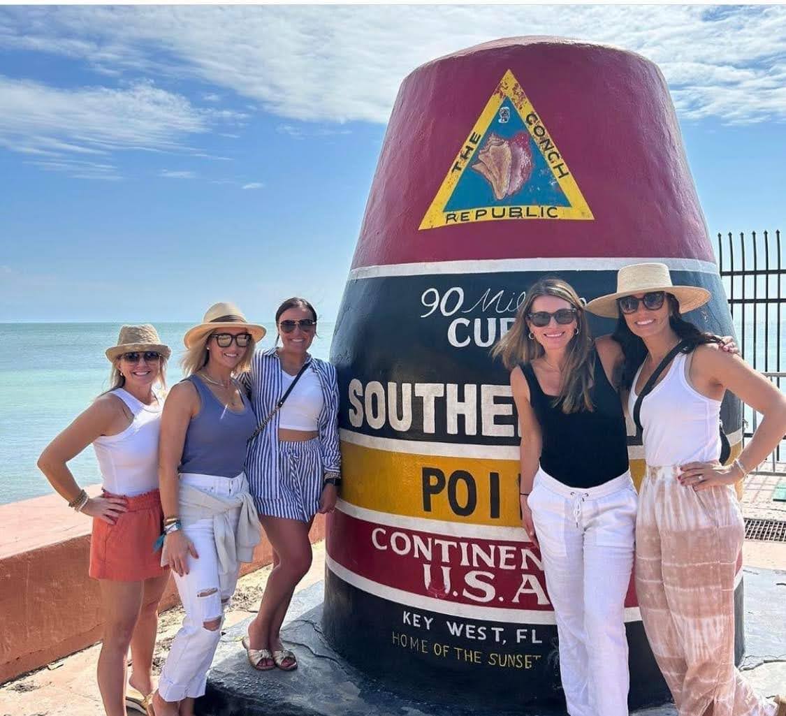 People posing in front of a big buoy structure