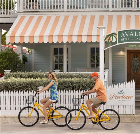 A couple riding bicycles in front of Avalong Bed and Breakfast