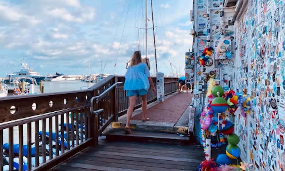 woman walking around jimmy buffet memorial wall