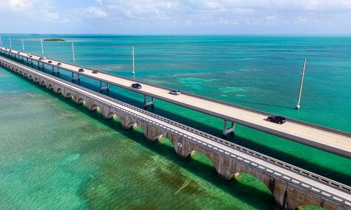 cars driving over long bridge over water