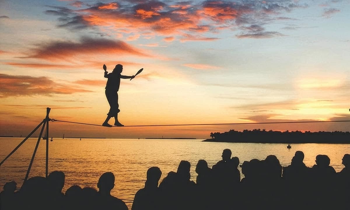 A person walking a tight rope in front of a crowd