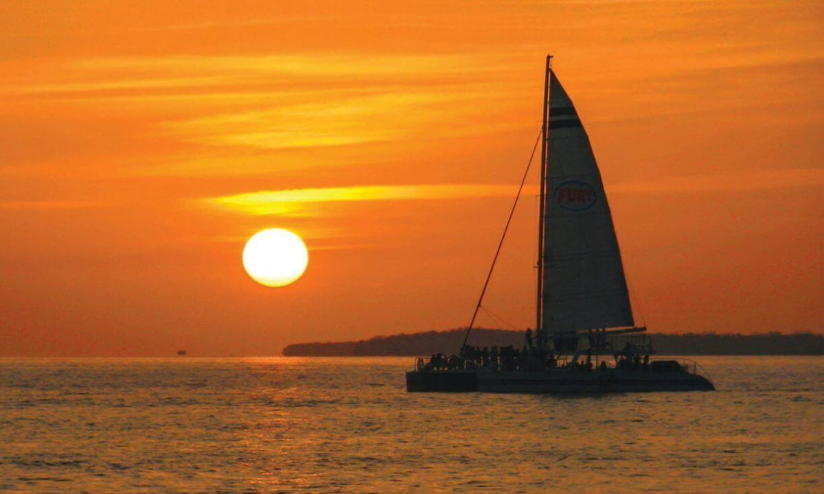 sail boats on the water at sunset