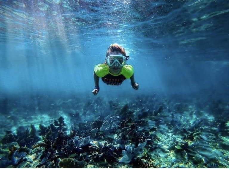 kid snorkeling in shallow waters