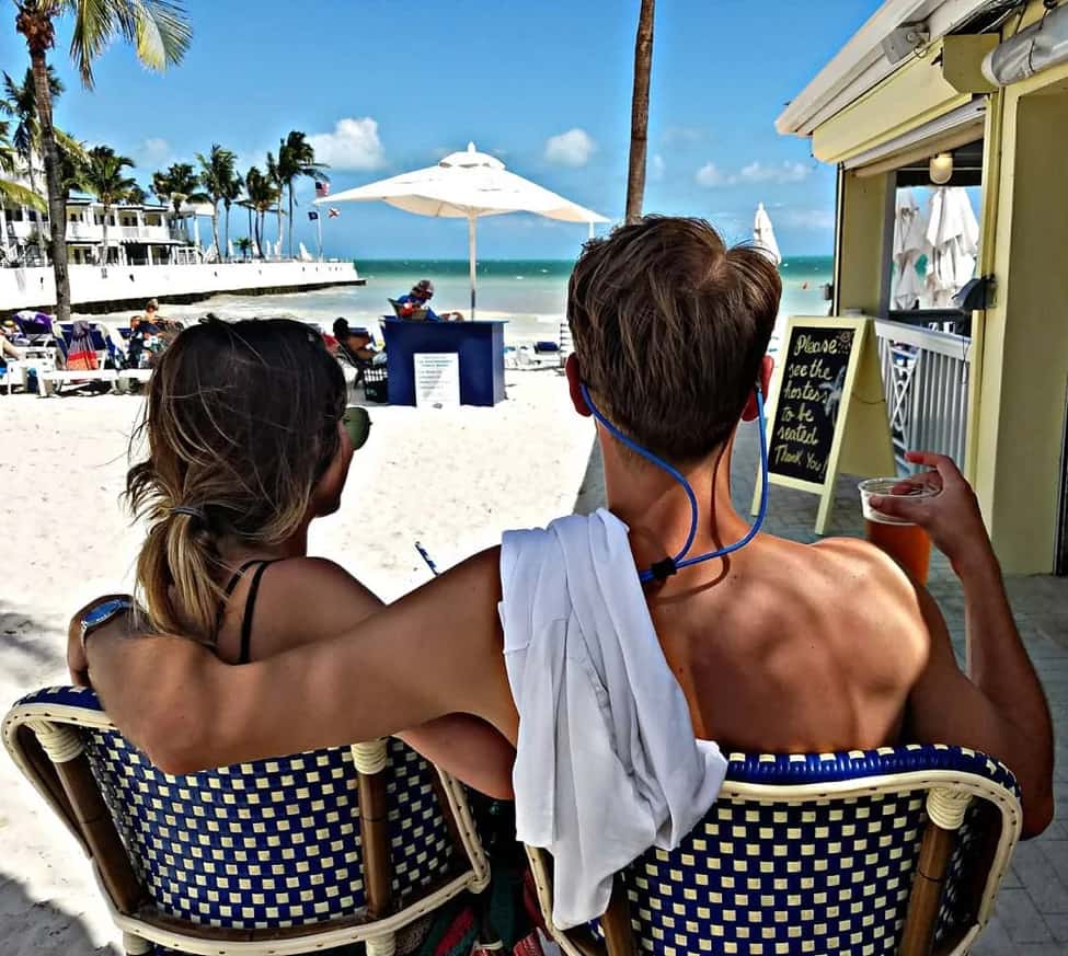 couple sitting in chair by beach