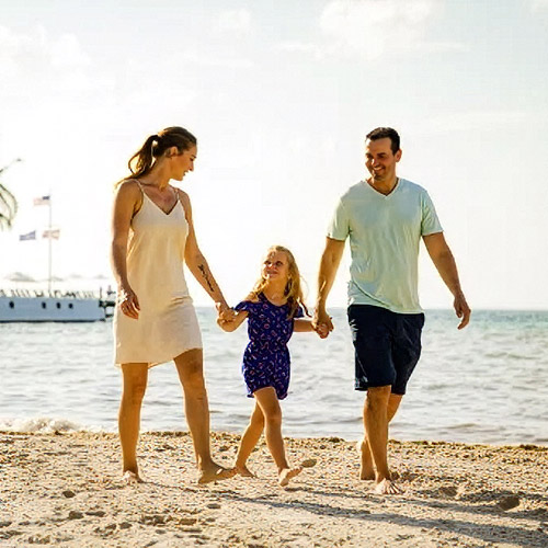A family walking together on the beach on a sunny day. 