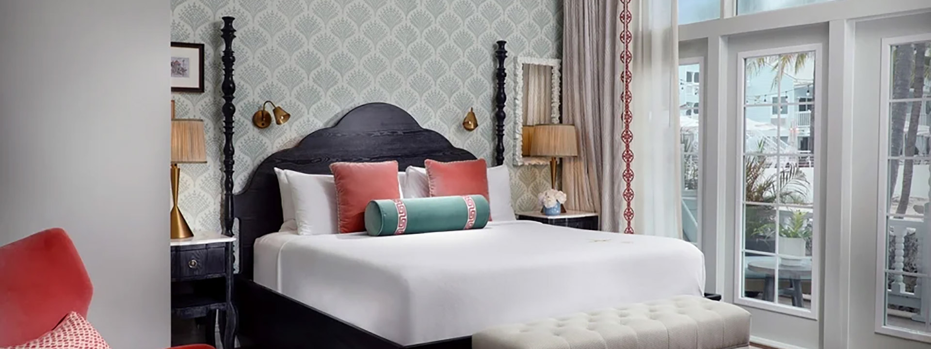 A hotel room with a bed, nightstand, and window