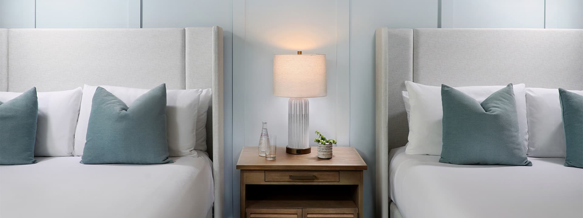 A close-up view of two twin beds with white bedding and blue accents in a room at Southernmost Beach Resort.